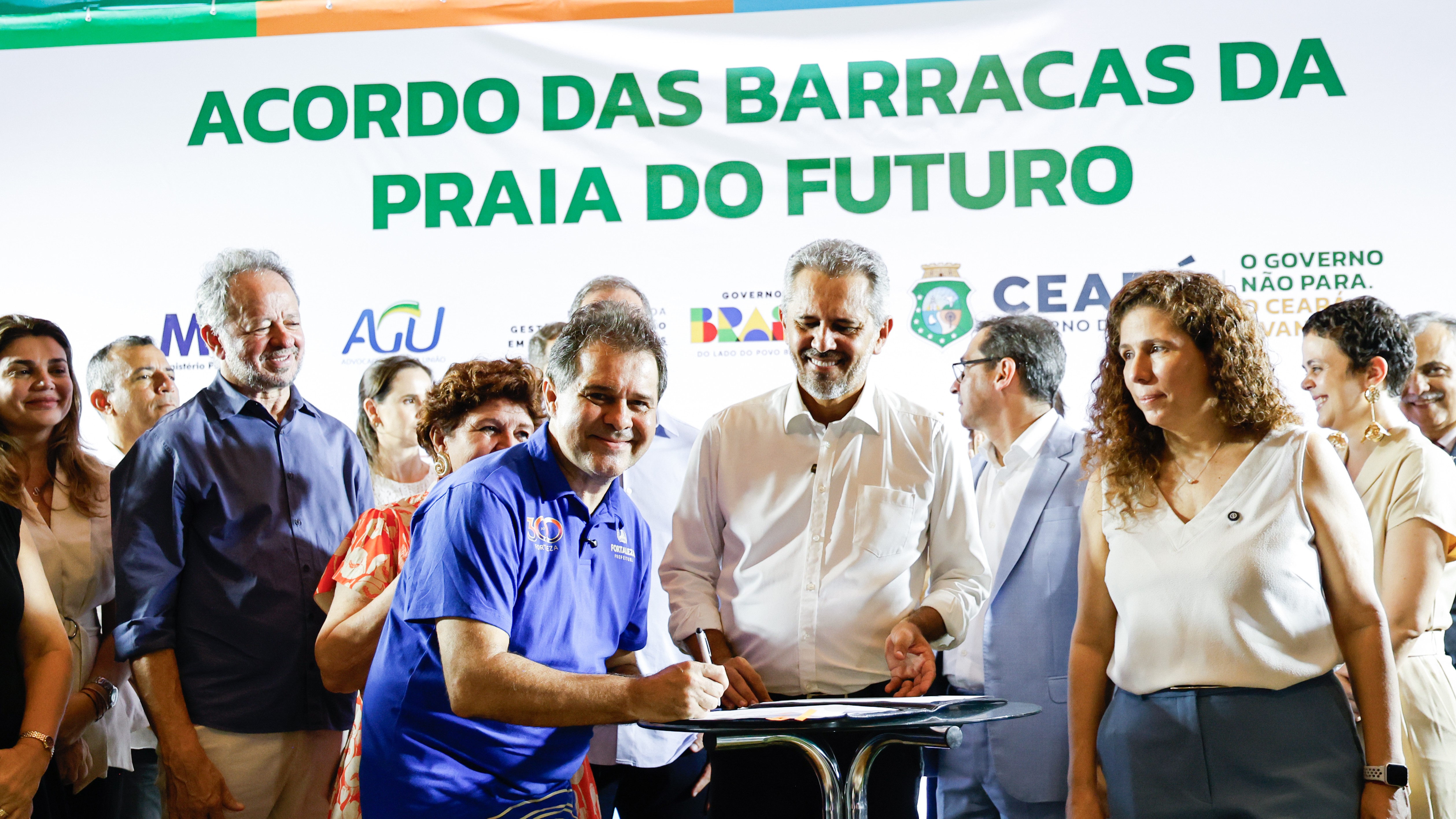 Prefeito Evandro assinando um documento no palco